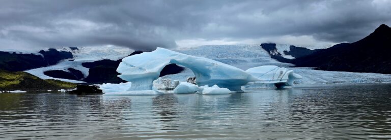 A photo os a floating section of ice with a circle in the middle that was formed in the glacier by swirling water