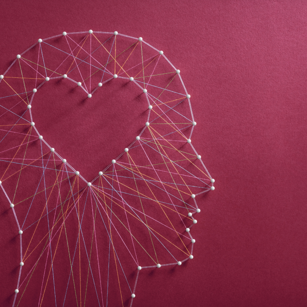 Image of an outline of a head, made with pins and thread, showing a heart where the brain is.